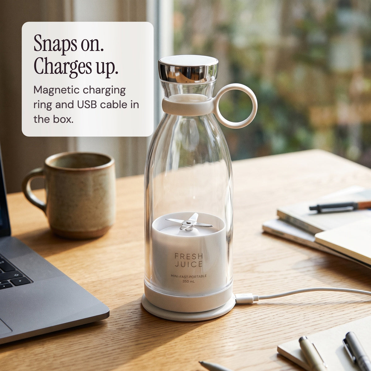 White Swirlette charging on its magnetic charging ring on a desk.