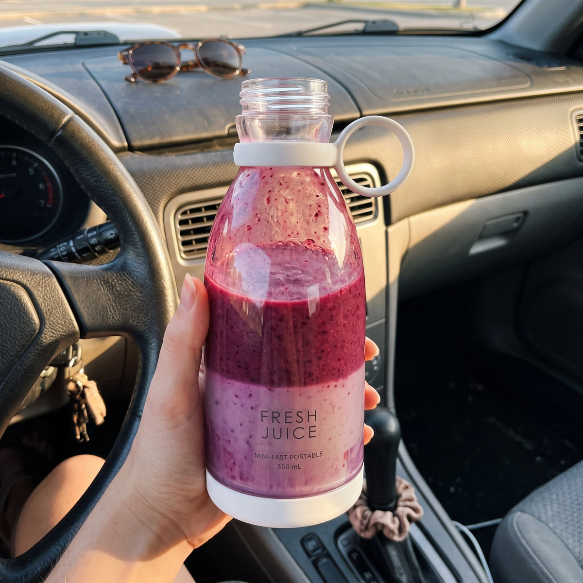 Holding a White Swirlette full of berry smoothie in the car.